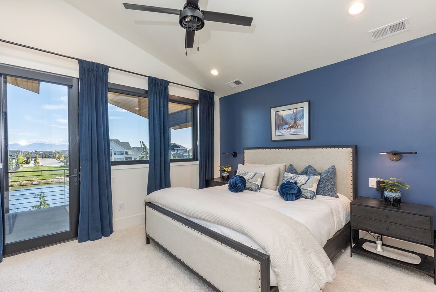 A bedroom with a king size bed and a ceiling fan.