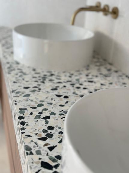A bathroom counter with two sinks and a faucet.