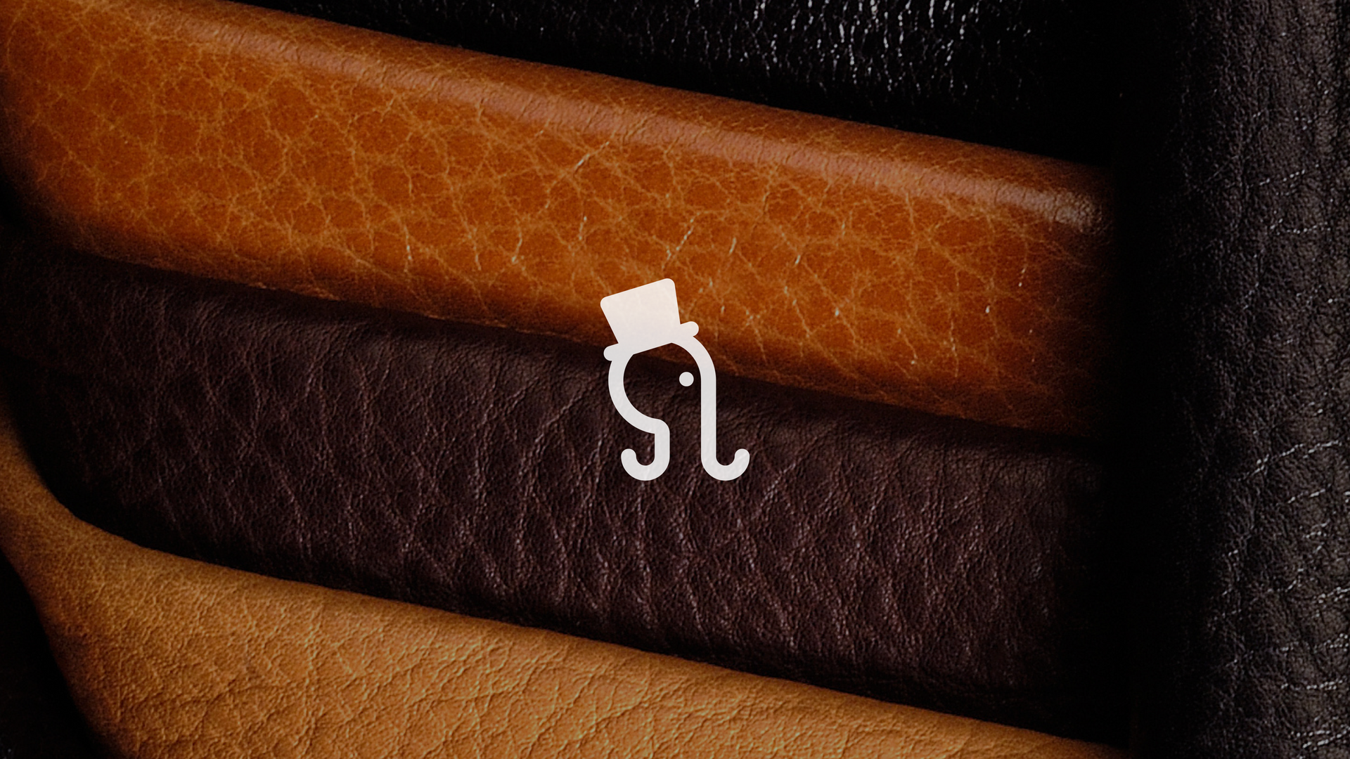 Close-up of stacked leather belts in brown and black with a white clasp