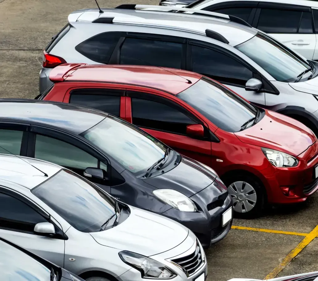 A row of cars are parked in a parking lot.