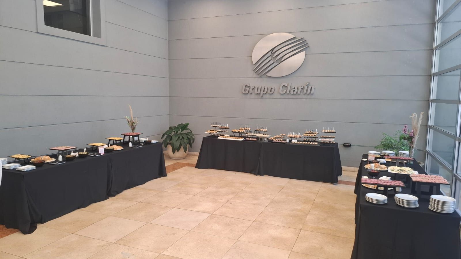 Mesas de buffet con comida en una sala con un logotipo que dice