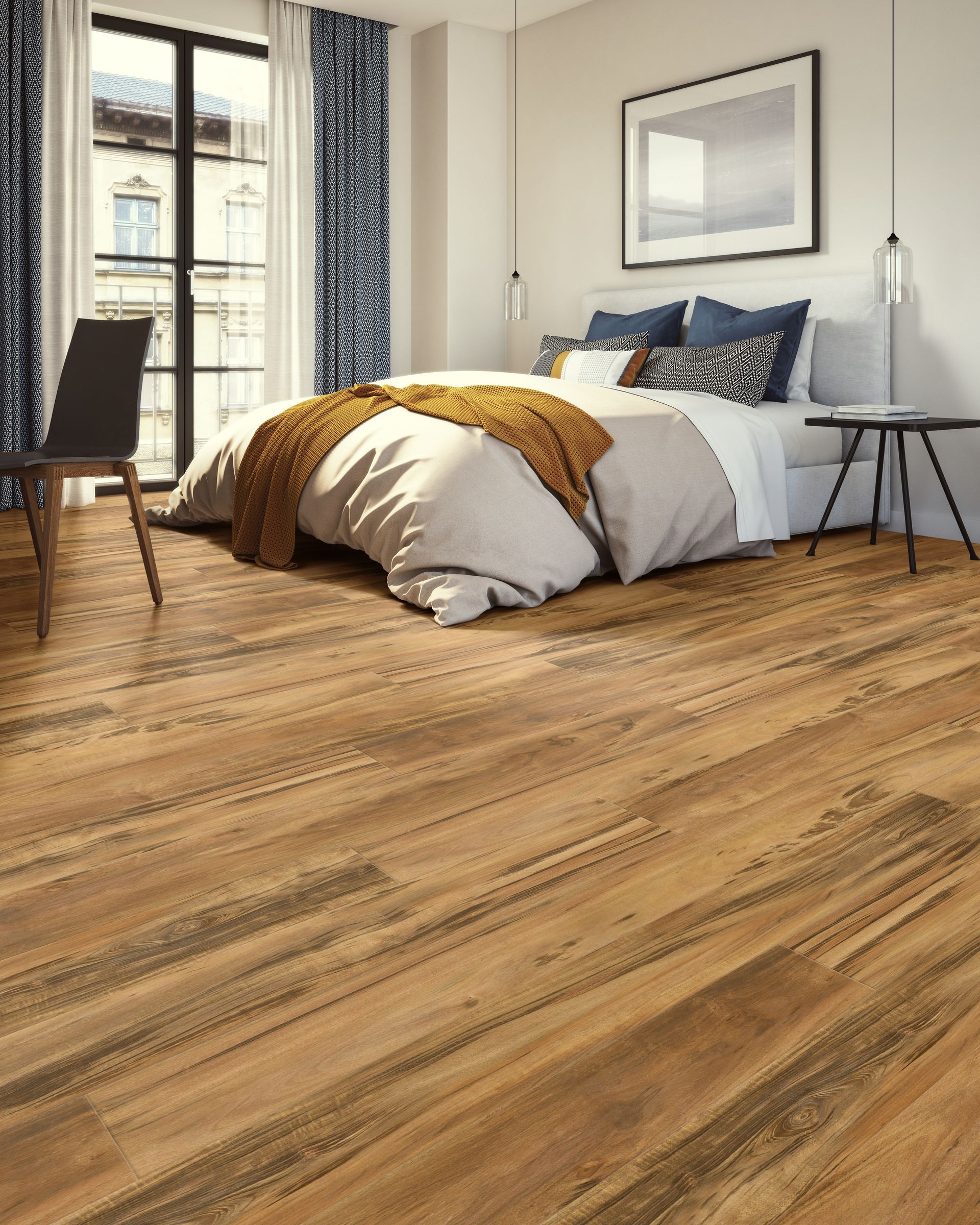 Modern bedroom with wood flooring, bed, framed wall art, side tables, and large window curtains.