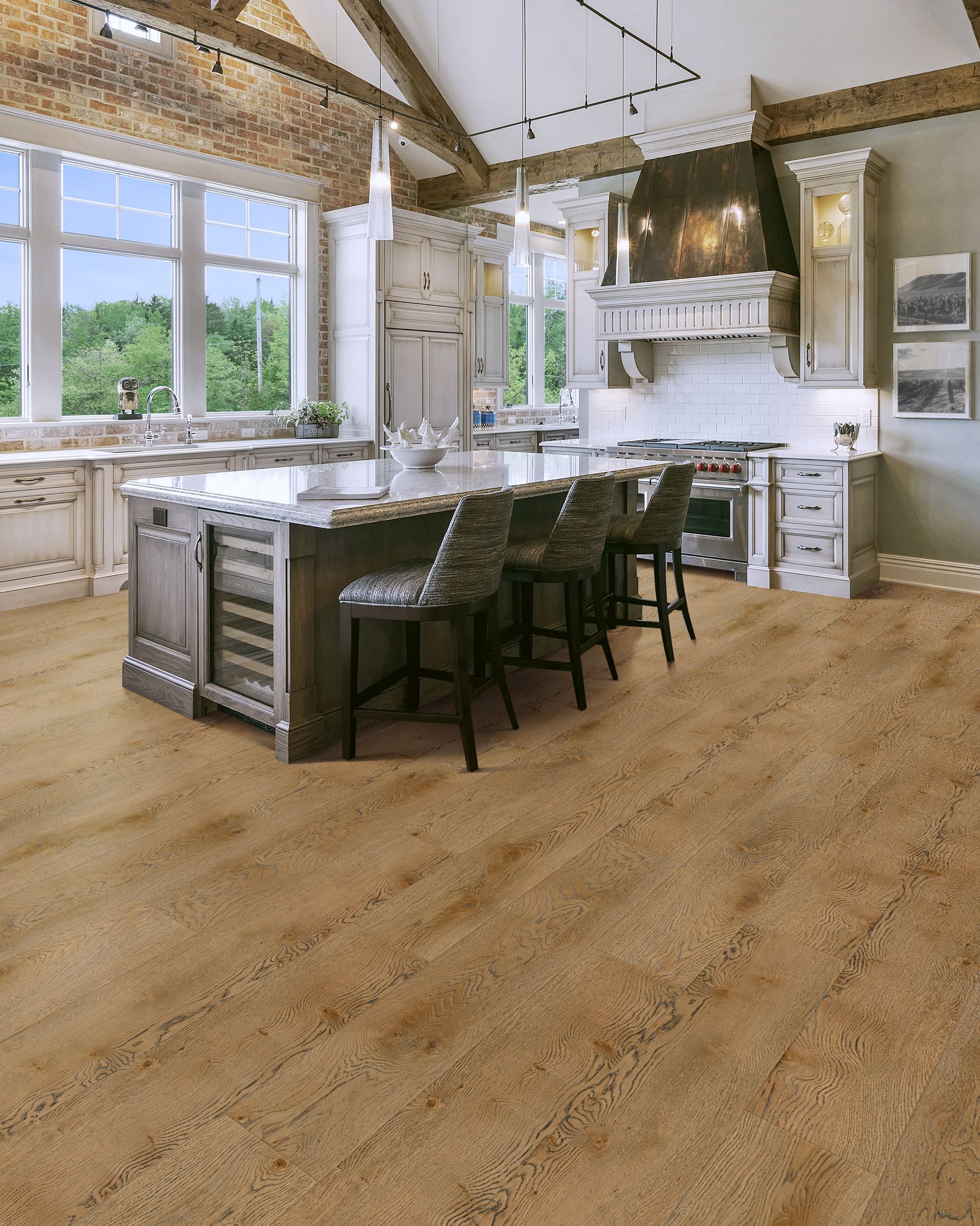 Modern kitchen with large island, white cabinets, and tall windows letting in natural light.