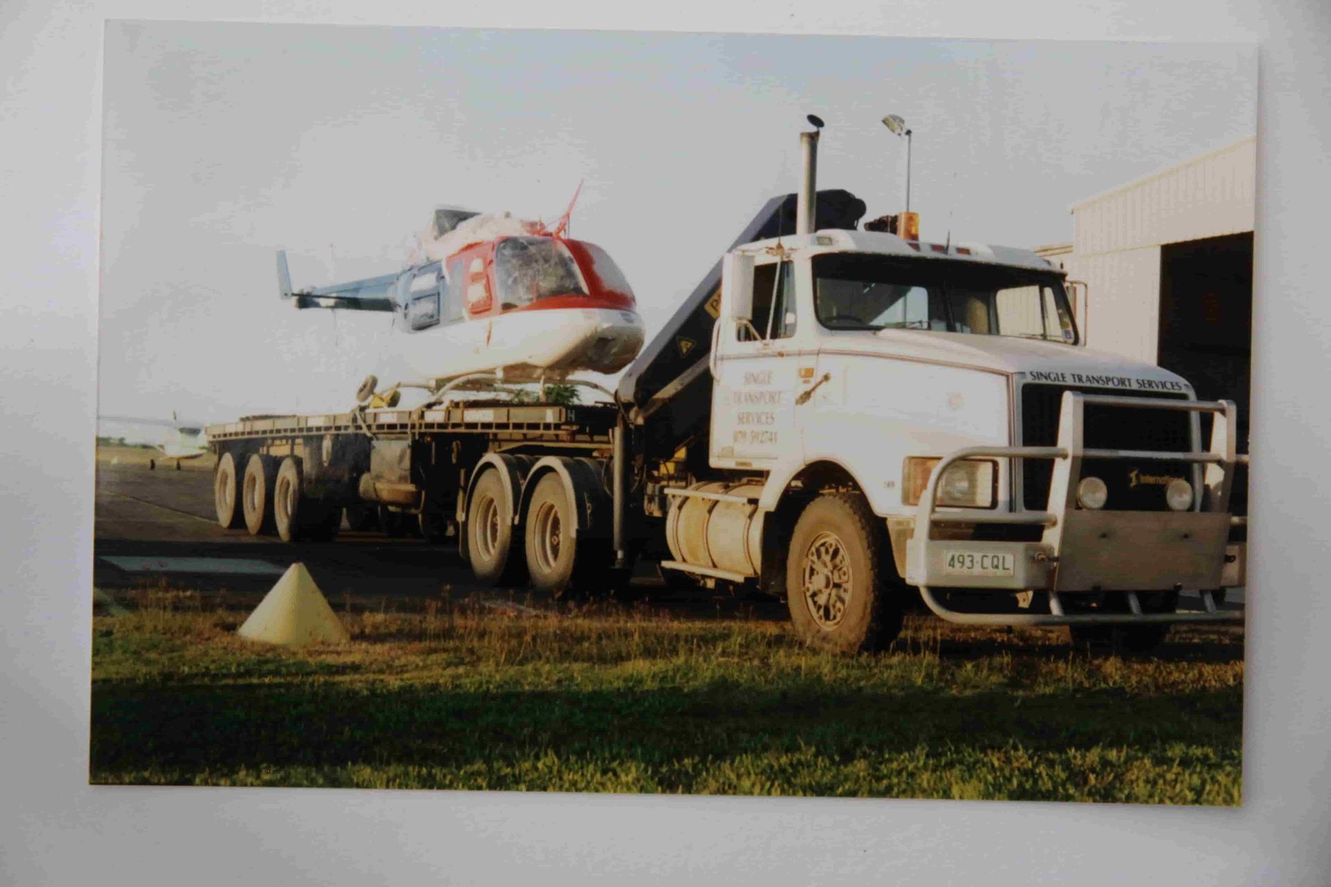 A White Truck With A Helicopter On The Back Of It — Single Transport Services In Palmyra, QLD
