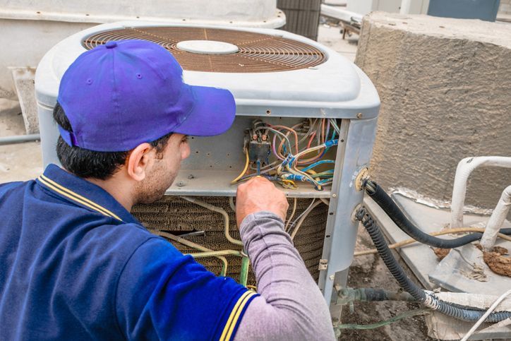 A professional electrician man is giving up thumbs up after the fixing a heavy duty air conditioner