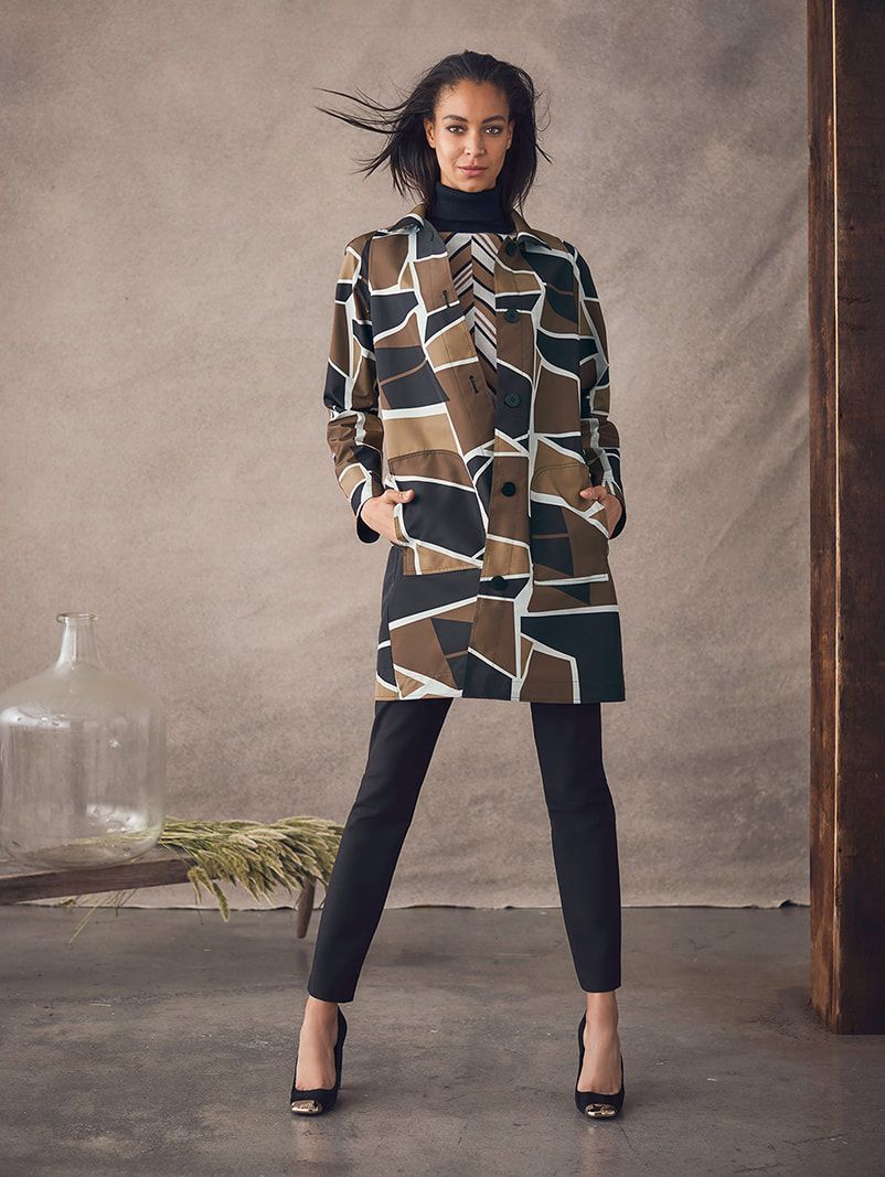 A woman is wearing a camouflage coat and black pants.