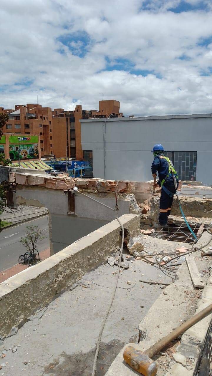 Un trabajador con ropa azul se encuentra en una azotea dañada