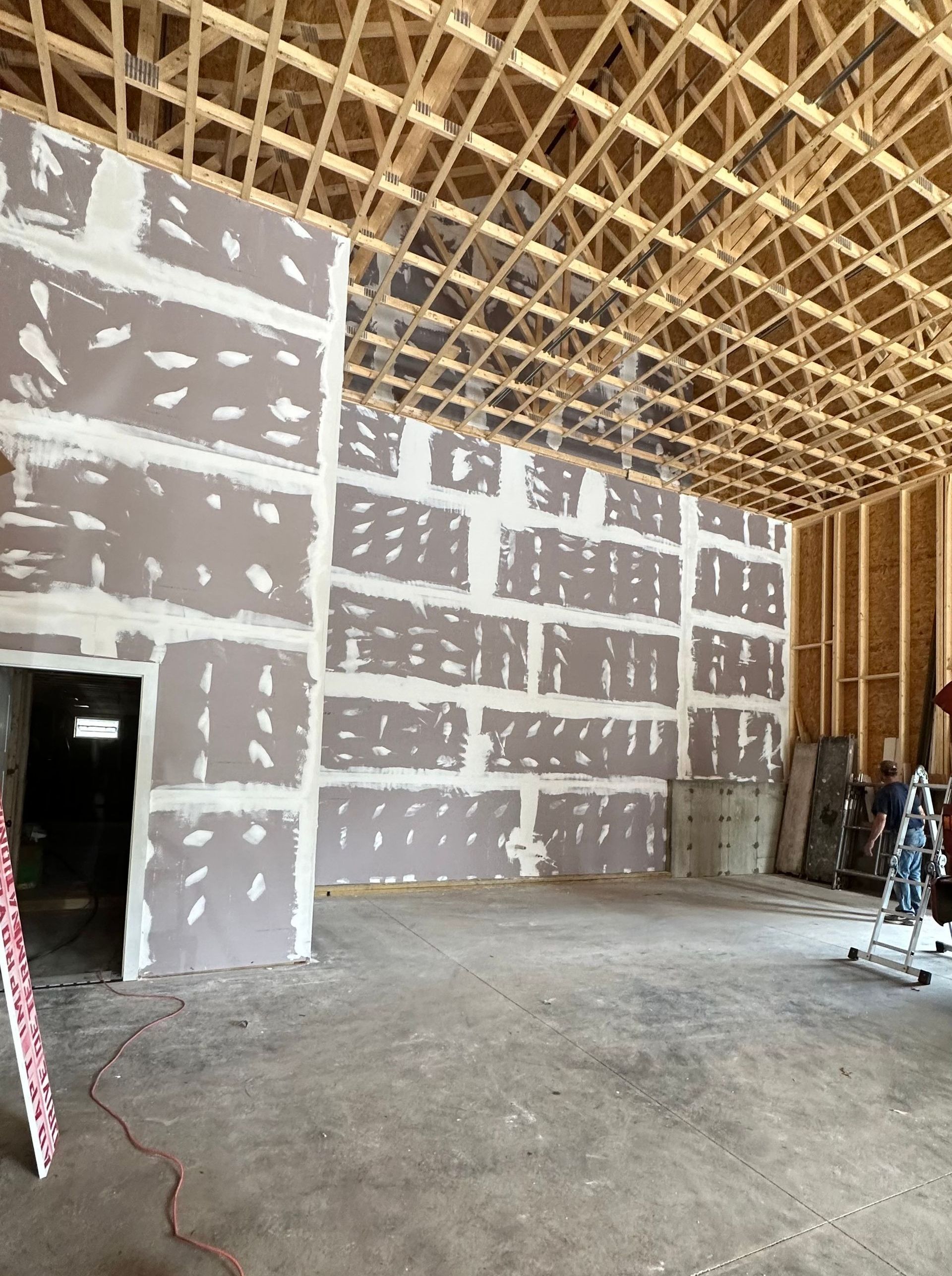 A large room with a lot of drywall and a wooden ceiling.