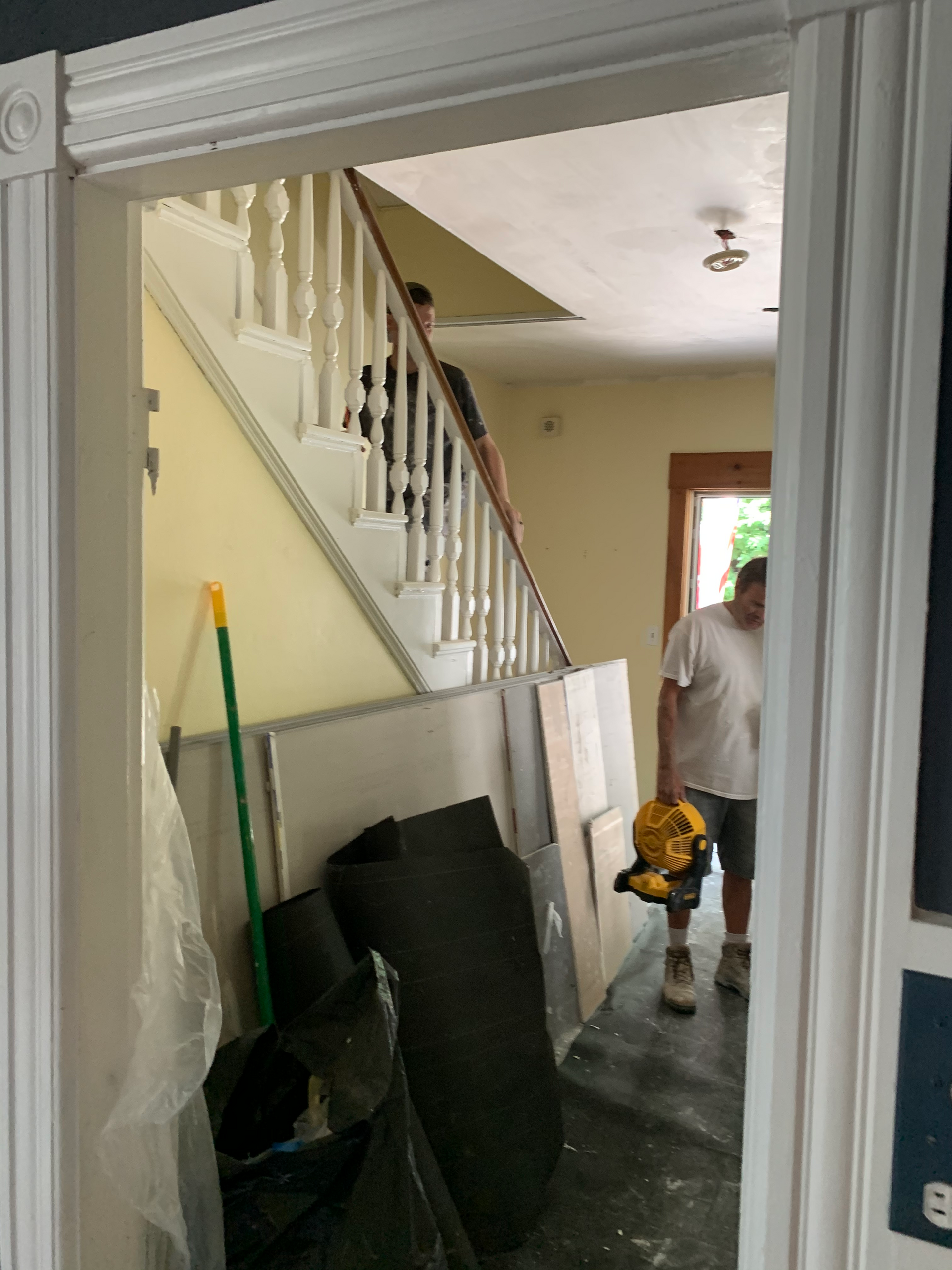 A man is standing in a room with stairs in the background