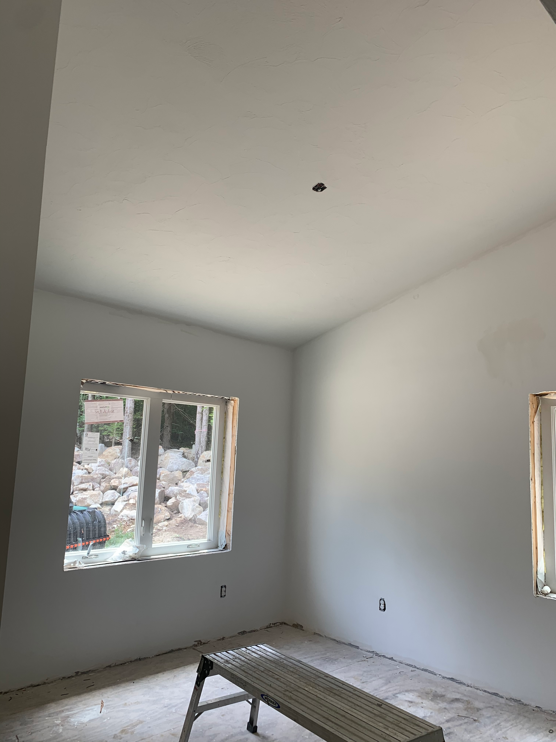 A room with two windows and a bench in it.