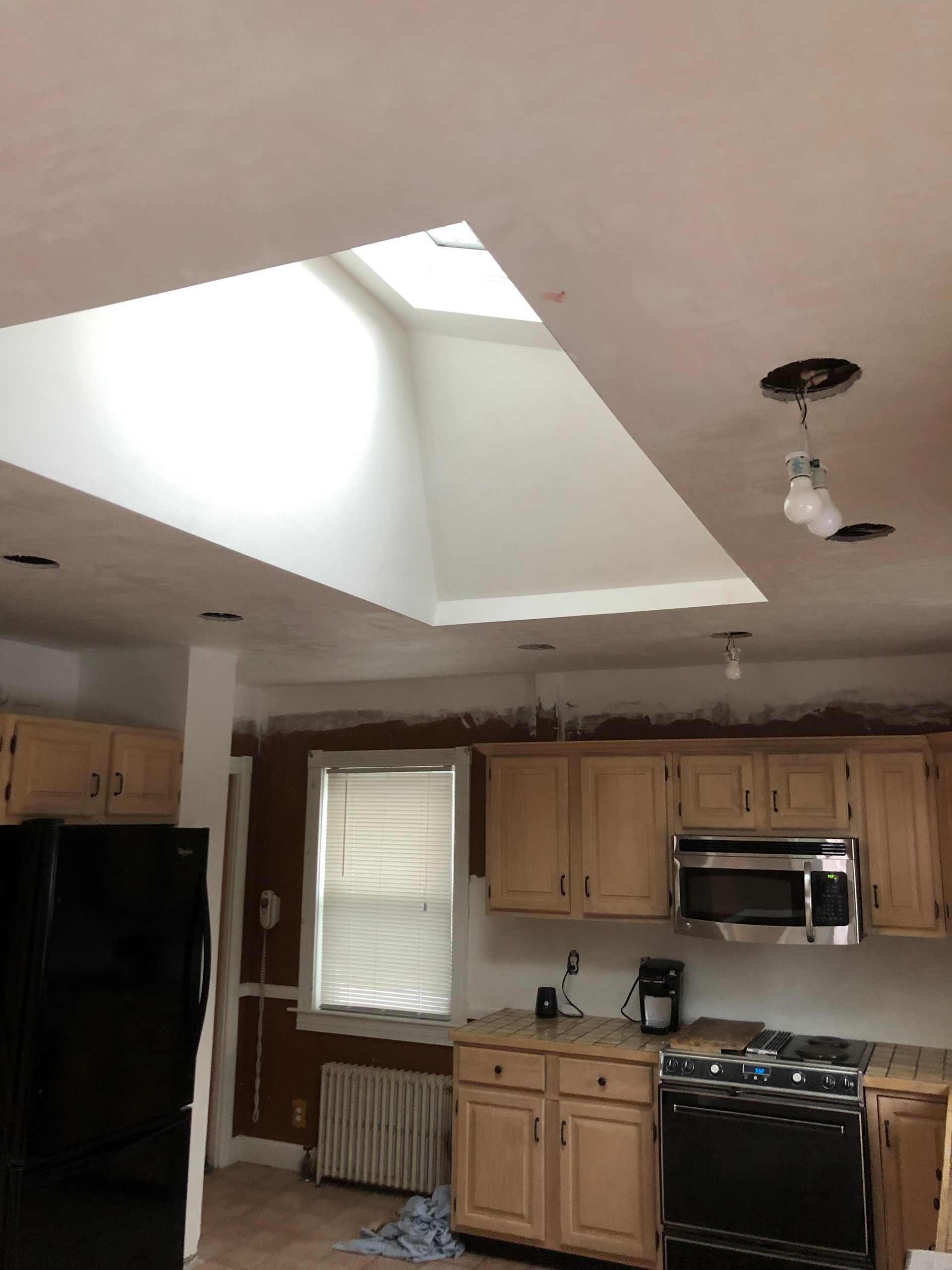 A kitchen with a skylight in the ceiling