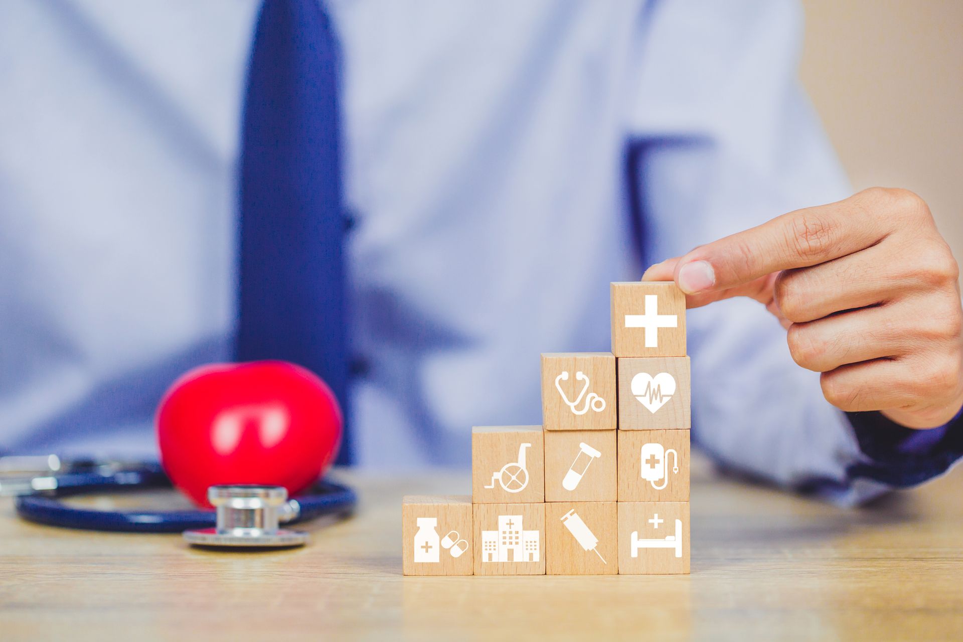 Doctor stacking healthcare-themed blocks representing medical services and highlighting structured value-based care.