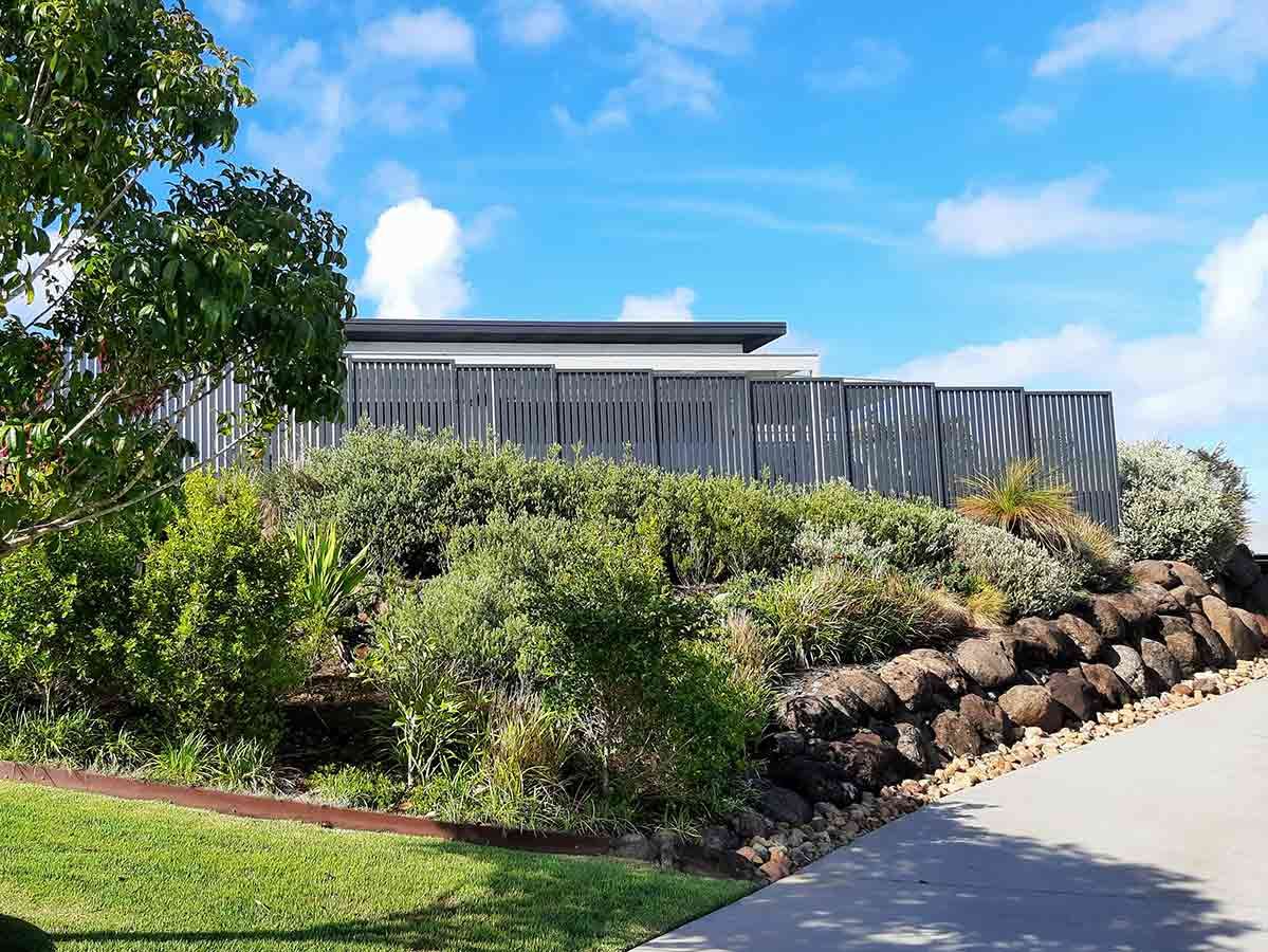 A Large House is Sitting on Top of a Hill Surrounded by Trees and Bushes — Full Circle Landscaping in Currumbin Valley, QLD