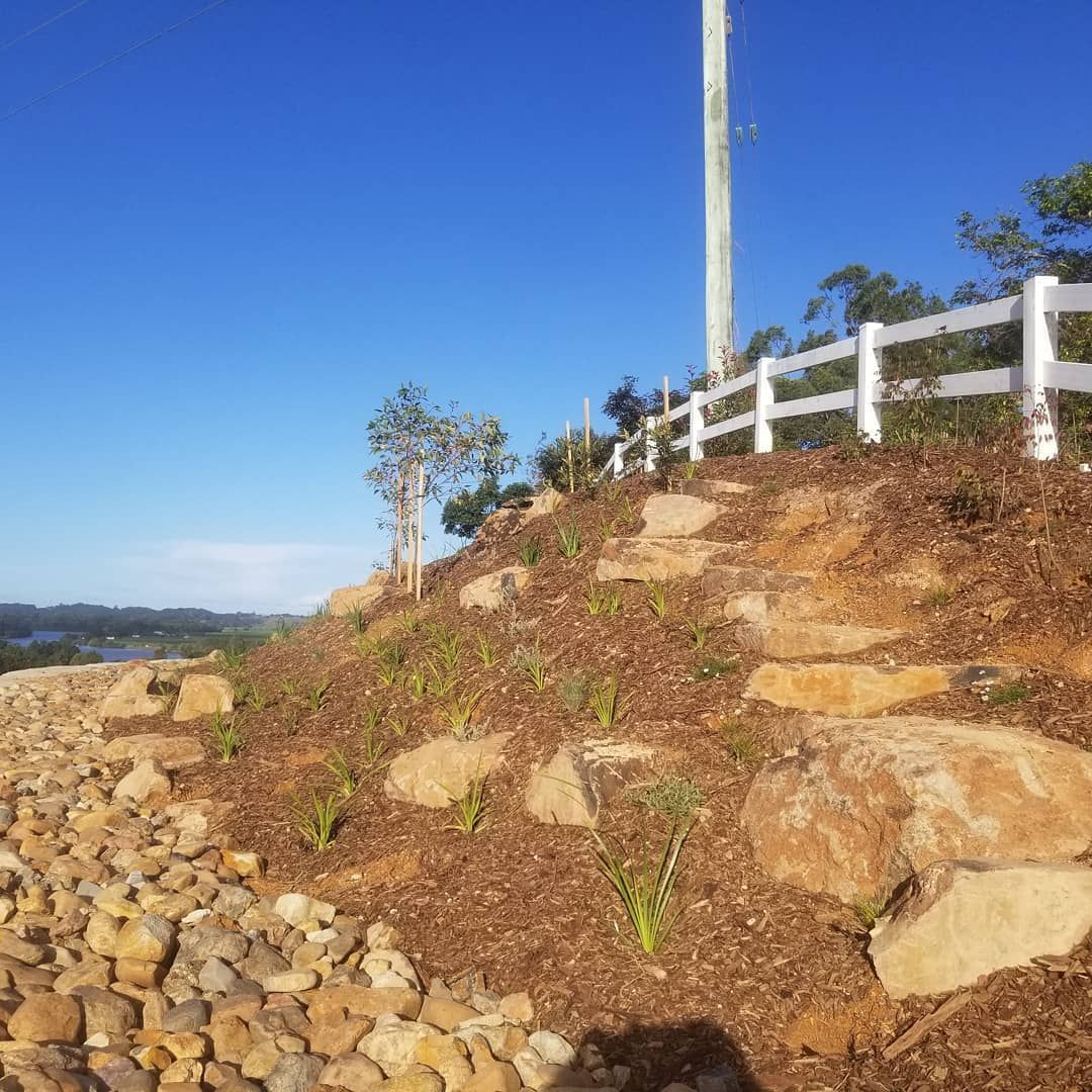 A Stone Walkway Leading To A Bench In A Garden — Full Circle Landscaping in Uki, NSW
