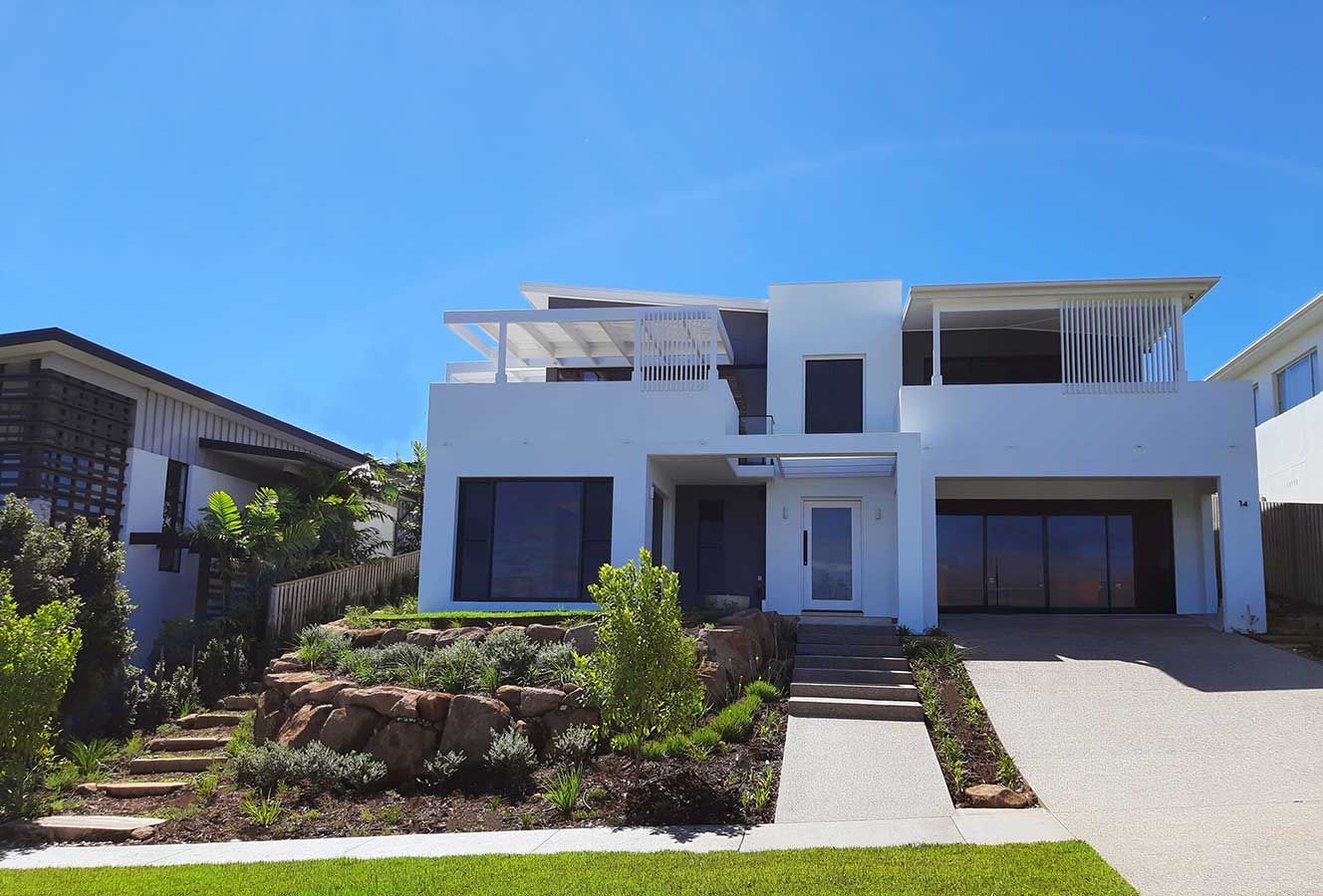 A Large White House With a Blue Sky in the Background — Full Circle Landscaping in Currumbin Valley, QLD