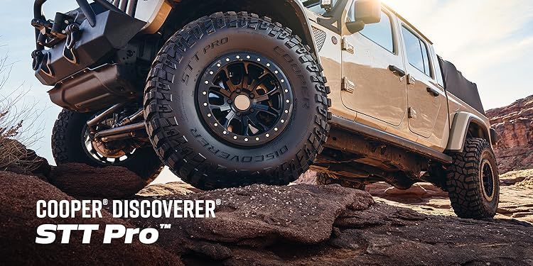 a jeep is parked on top of a rocky hill .