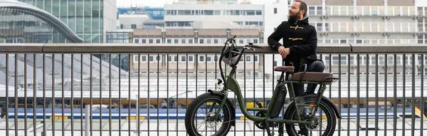 A man is riding an electric bike on a San Francisco bridge.