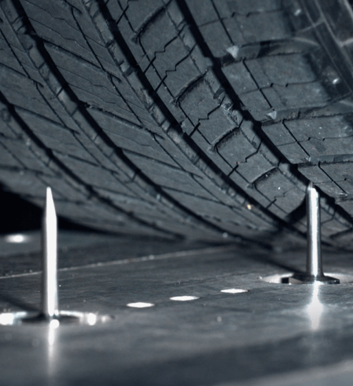 a close up of a tire with nails sticking out of it