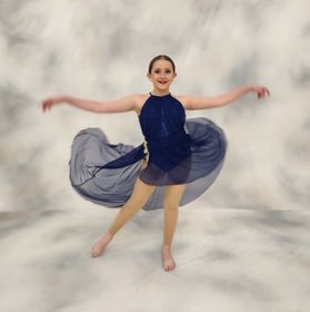 A girl in a blue dress is dancing with her arms outstretched A girl in a blue dress is dancing with her arms outstretched