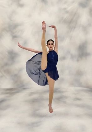 A Woman in A Blue Dress Is Doing a Split in The Air. A Woman in A Blue Dress Is Doing a Split in The Air.