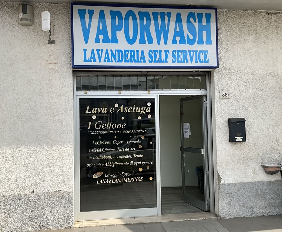 Vetrina di una lavanderia con insegna blu