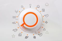 Icona di una lente d'ingrandimento arancione circondata da piccoli simboli grigi relativi al business e alla comunicazione su sfondo bianco.