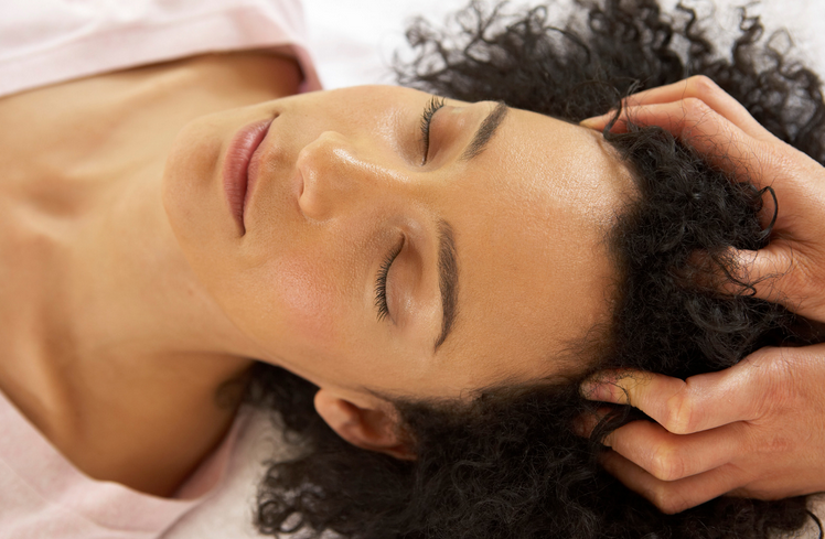 a woman is getting a facial at a spa with candles in the background