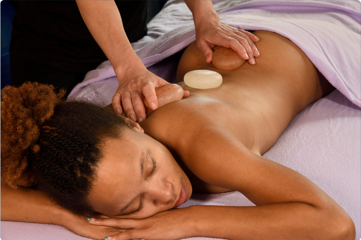 a woman with her eyes closed is getting her hair massaged