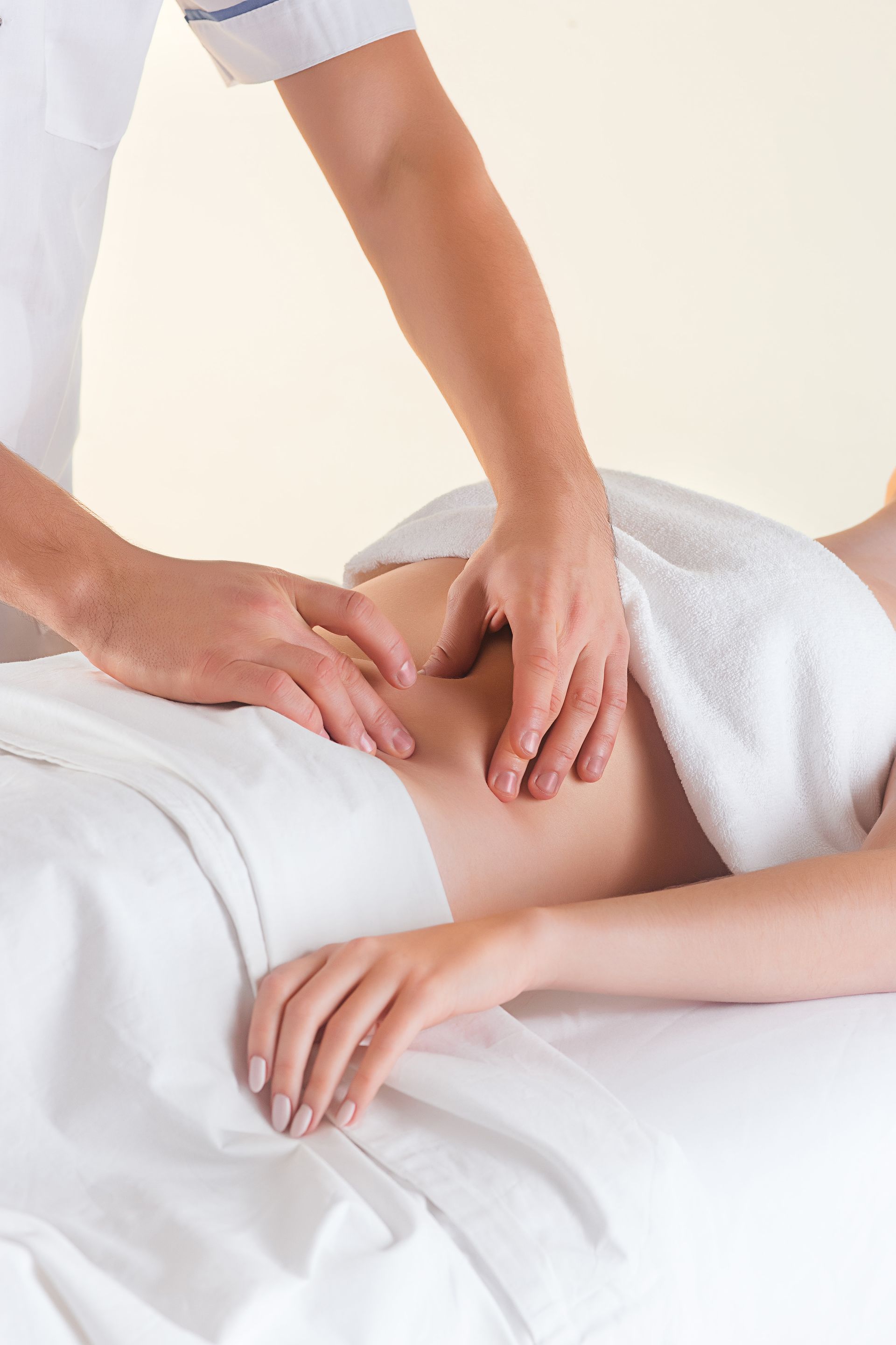 a woman is laying on a bed getting a massage from a man .