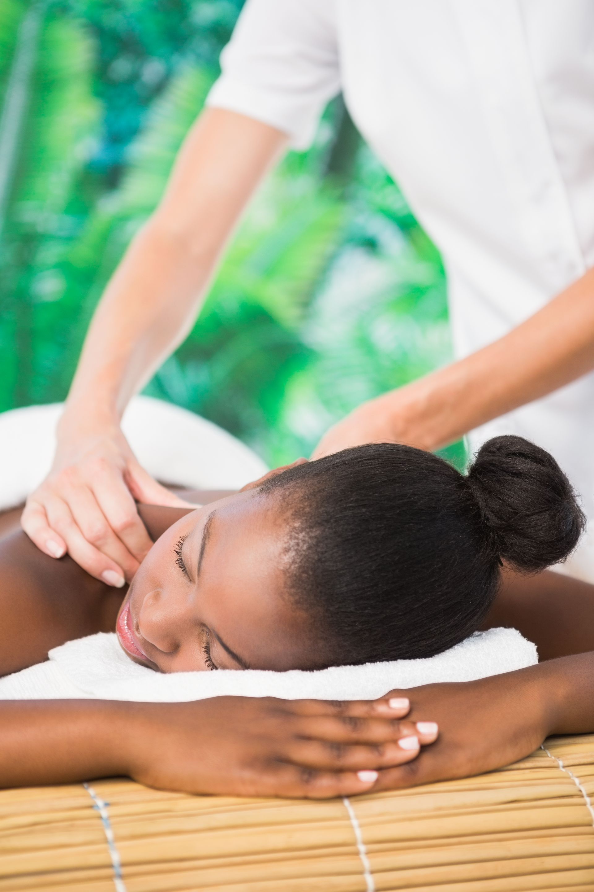 a woman is getting a massage with her eyes closed