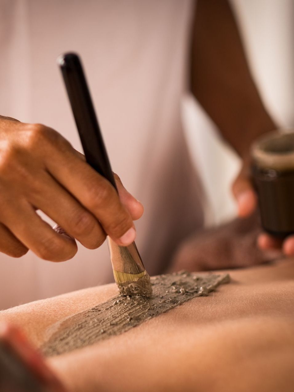 a person is applying a brush to a person 's back