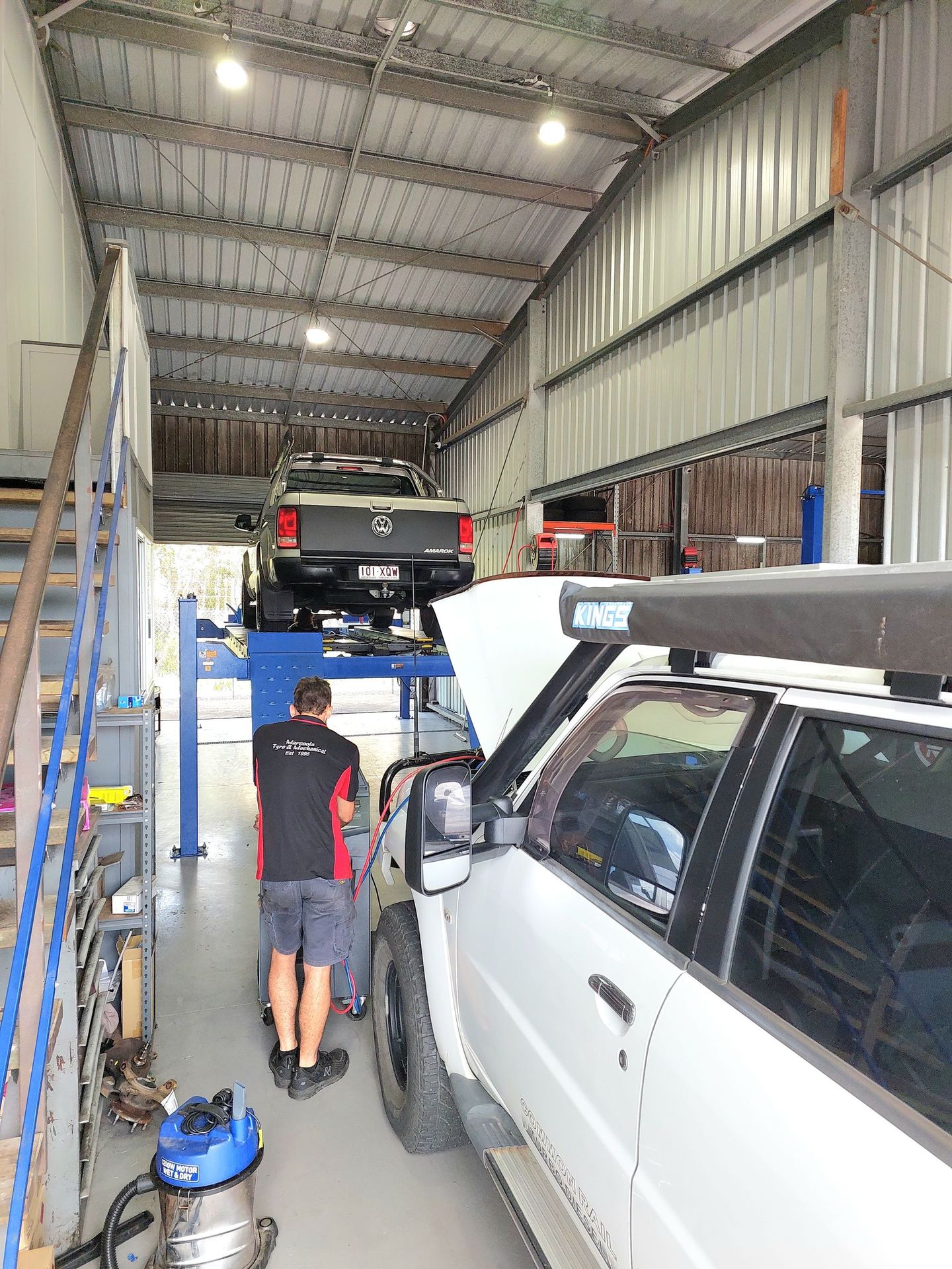A Man Is Standing In Front Of A Workshop Press — Marcoola Tyre & Mechanical In Marcoola, QLD