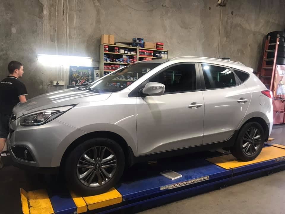 A Silver Suv Is Parked On A Lift In A Garage — Marcoola Tyre & Mechanical In Mudjimba, QLD