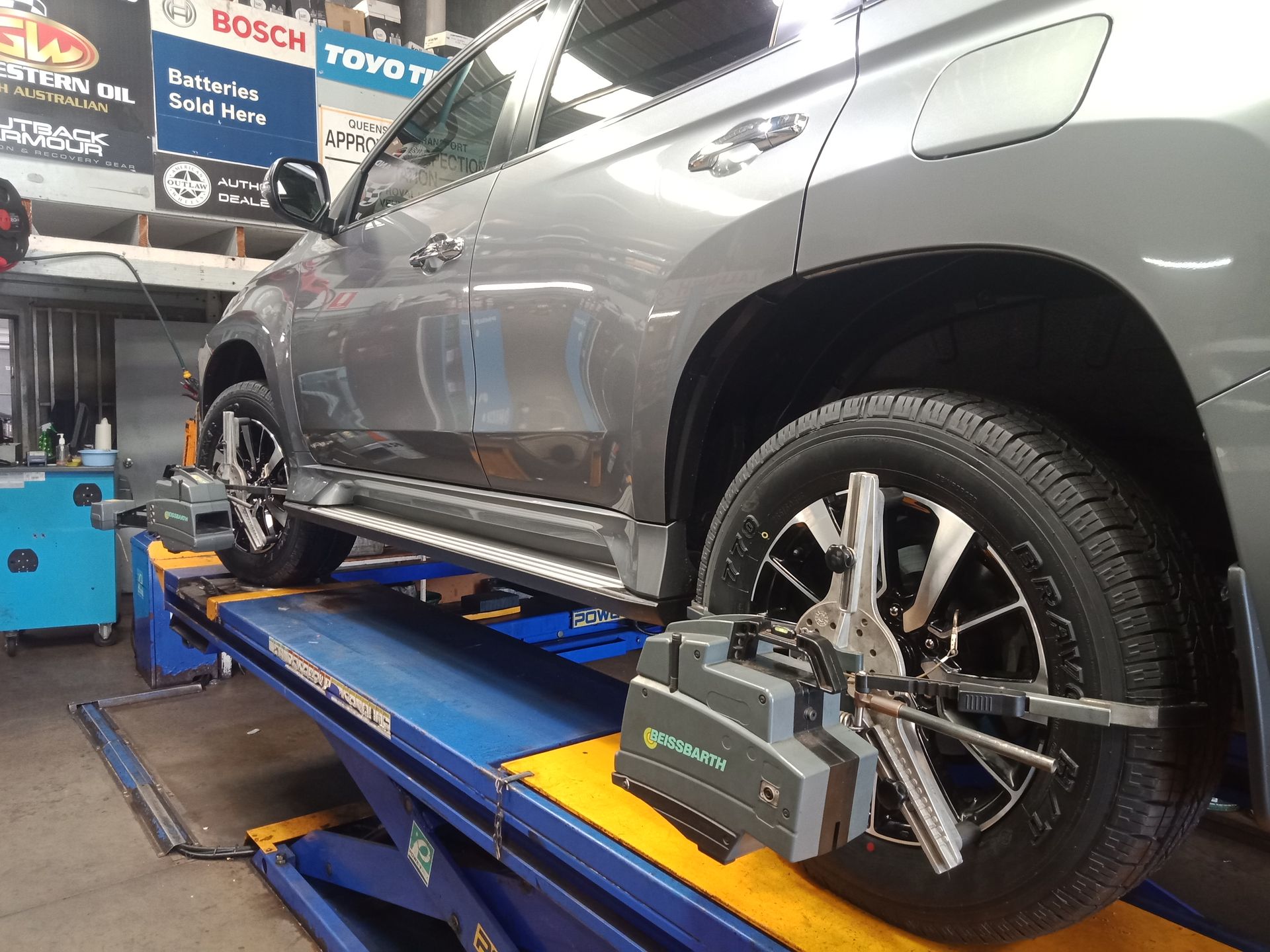 A Grey Car Is Getting A Wheel Alignment Done — Marcoola Tyre & Mechanical In Marcoola, QLD