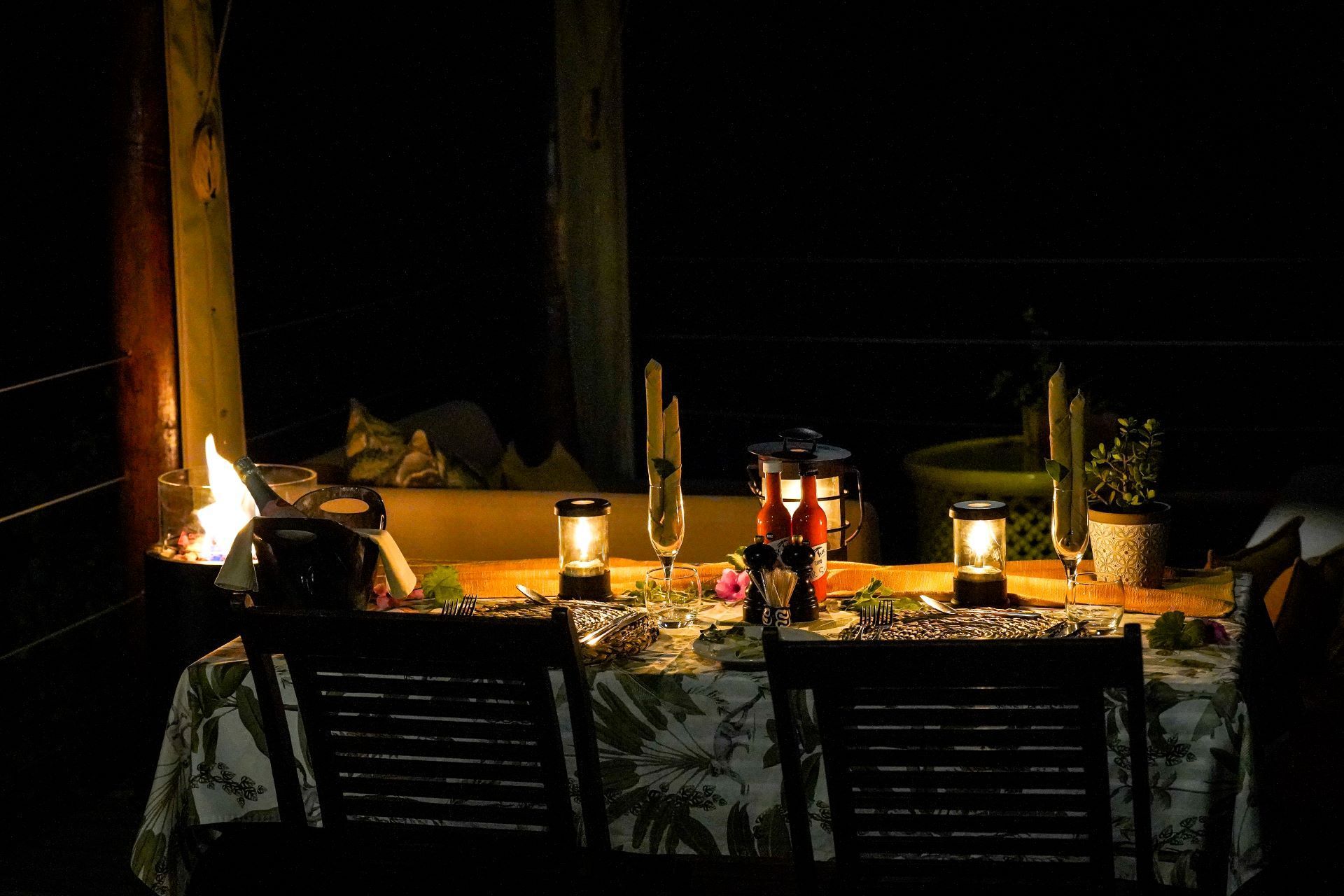 A table with lanterns and candles on it in the dark.