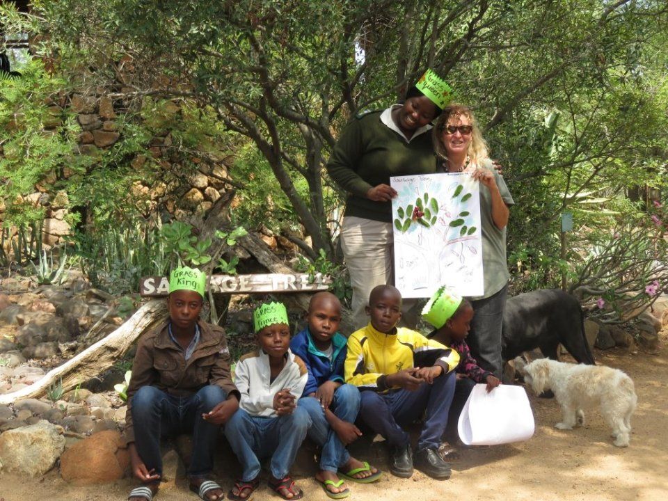 a group of children are posing for a picture in front of a sign that says savage creek