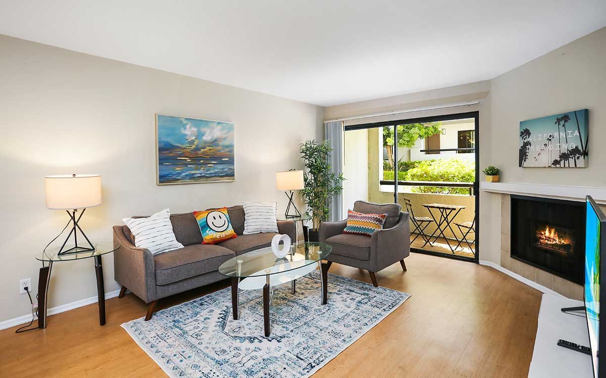 a living room with a couch , chair , table , fireplace and television .