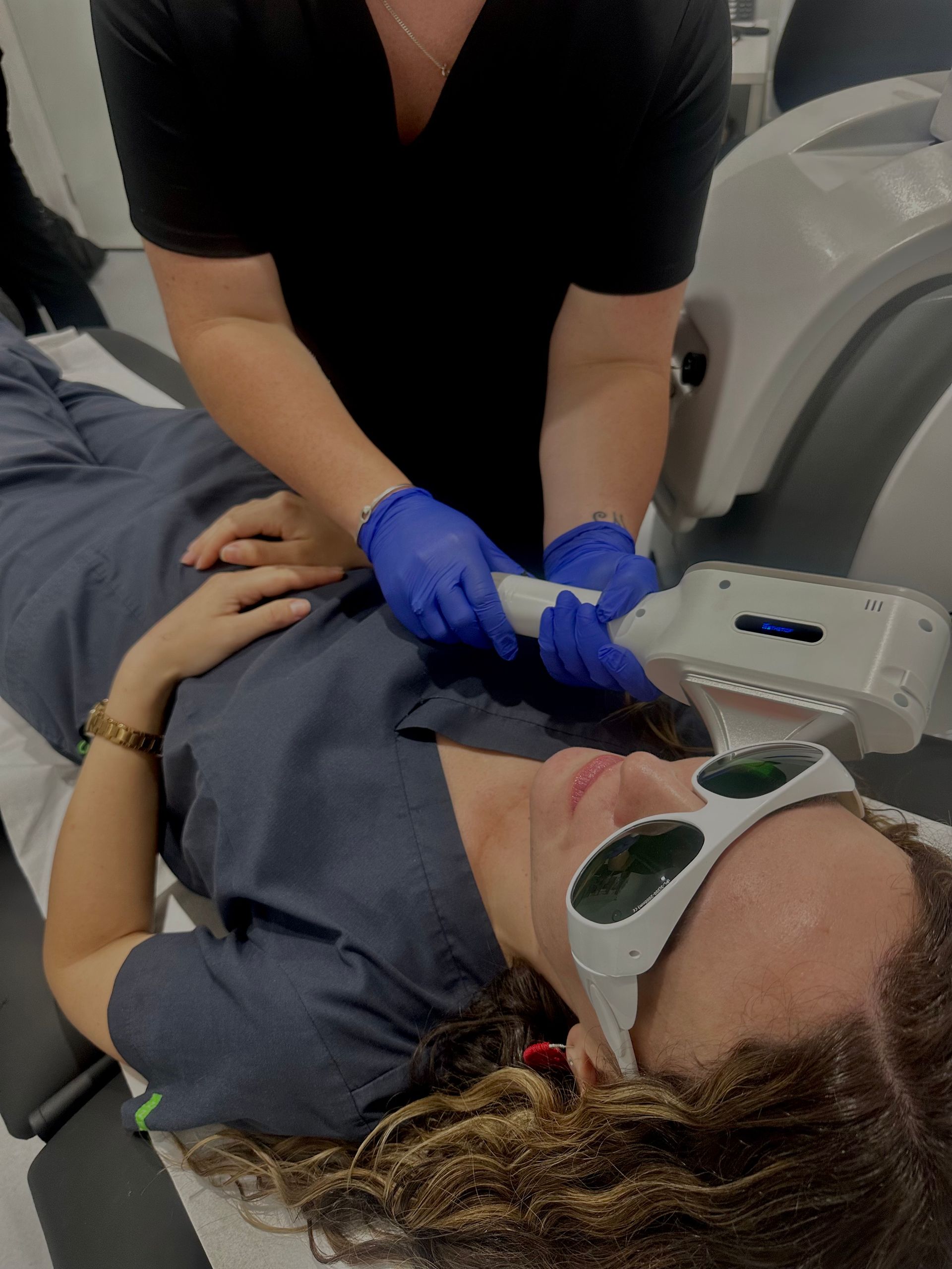 Person receiving laser hair removal treatment on neck, wearing safety glasses.— Hope Laser and Beauty Clinic In Tuncurry, NSW