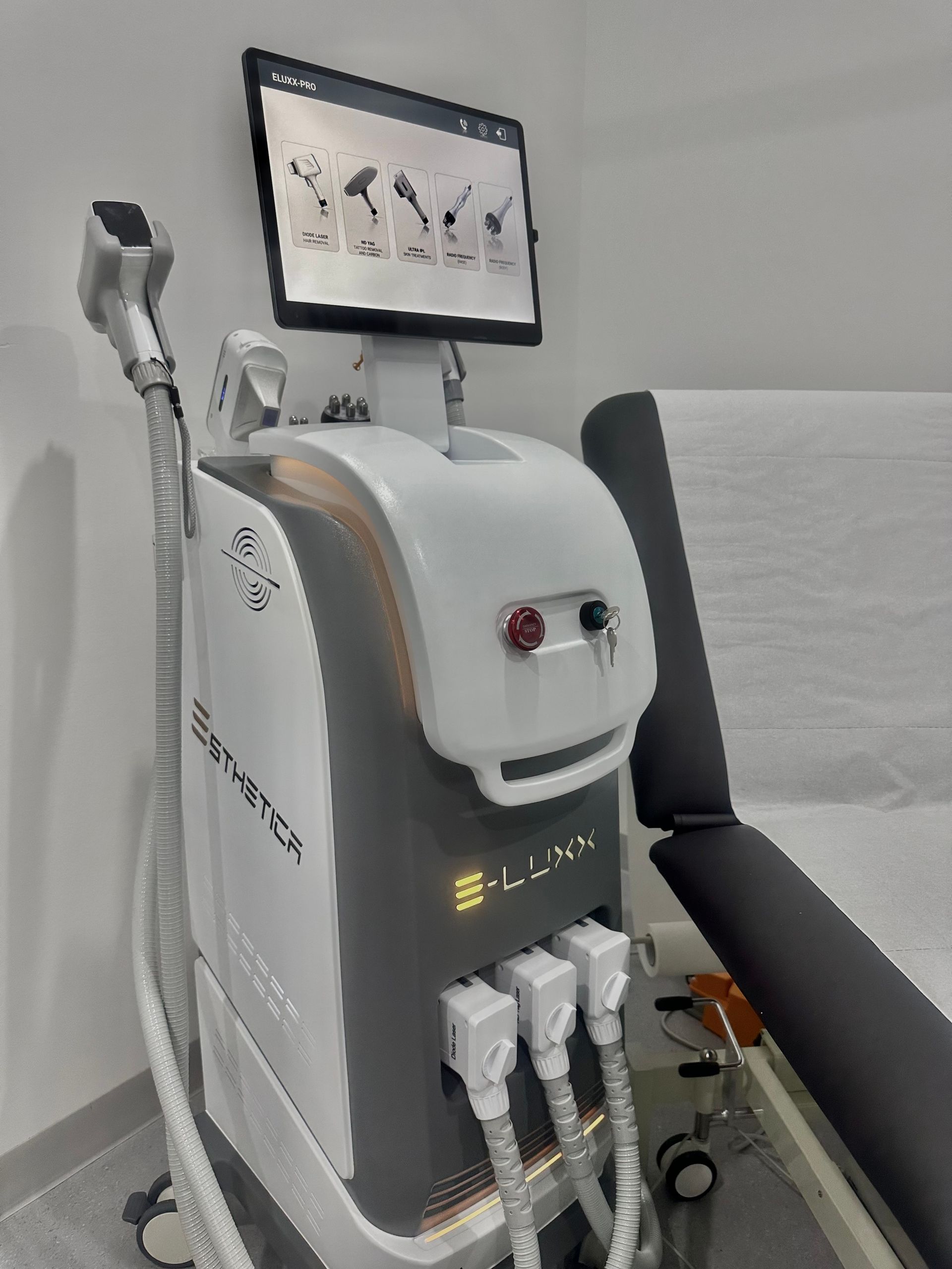 Medical laser device with screen, attached applicator, and chair in a clinic. — Hope Laser and Beauty Clinic In Tuncurry, NSW