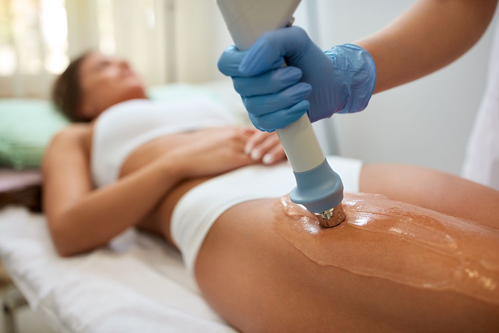 Person Receiving Treatment on Thigh With a Handheld Device — Hope Laser and Beauty Clinic In Forster, NSW