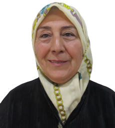 A woman wearing a scarf around her head smiles for the camera