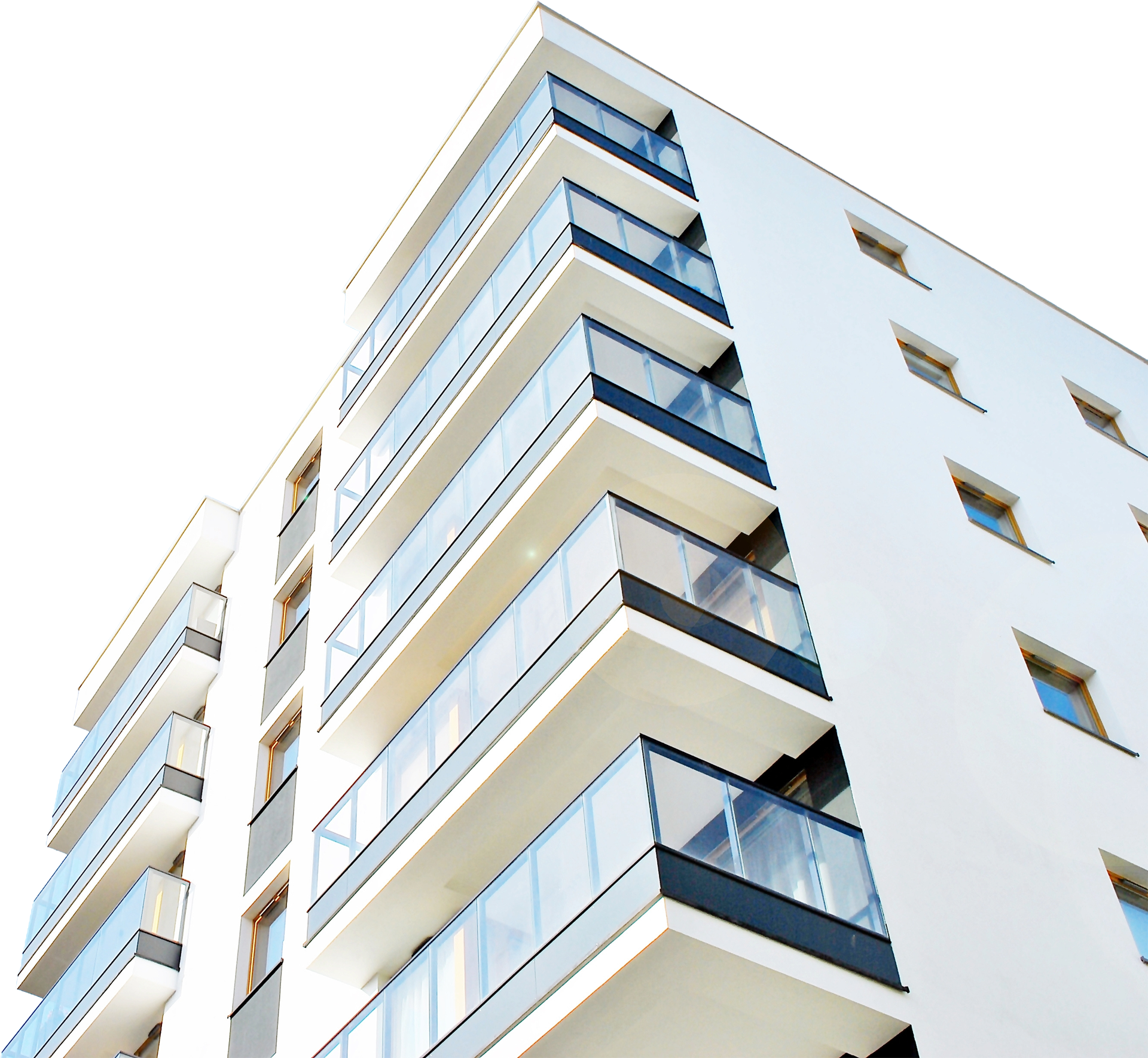 Modern white rendered apartment building with glass balconies, viewed from below against a bright sky