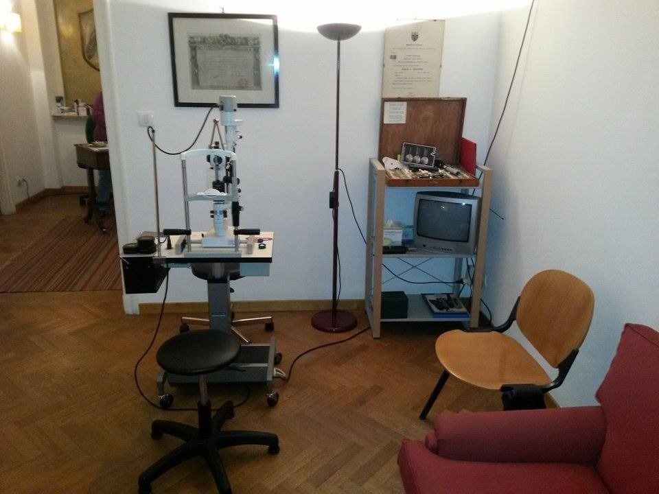 Una sala per visite oculistiche con attrezzatura, una sedia e un armadietto