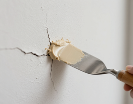 Reparar la grieta de la pared con espátula y masilla.