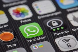 Primer plano de iconos de aplicaciones de smartphone, incluyendo WhatsApp, Threema y Pure, sobre una pantalla oscura.