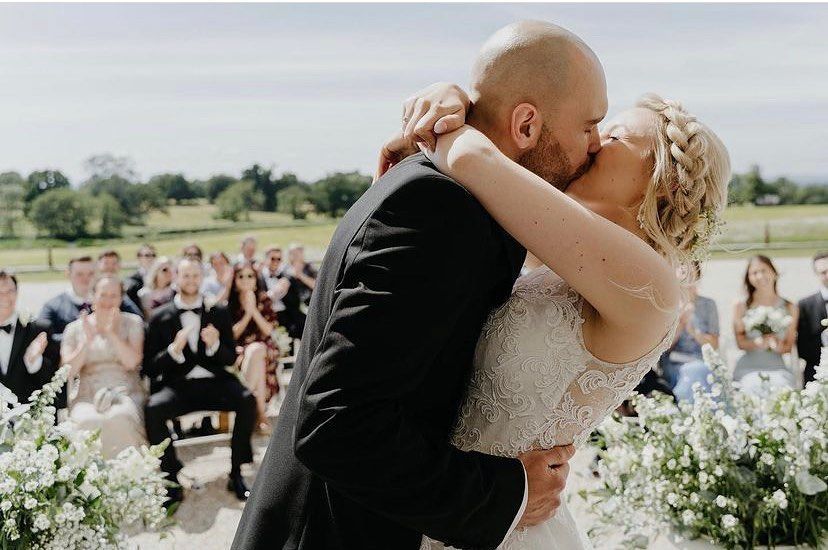 a bride and groom kissing in front of their wedding guests .