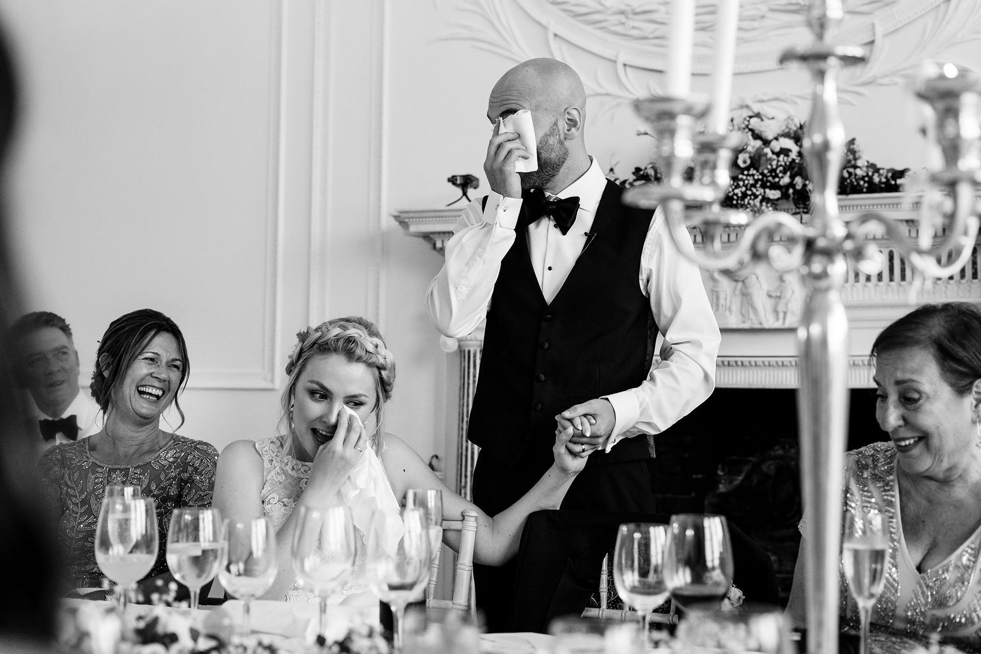 a black and white photo of a man giving a speech at a wedding reception .