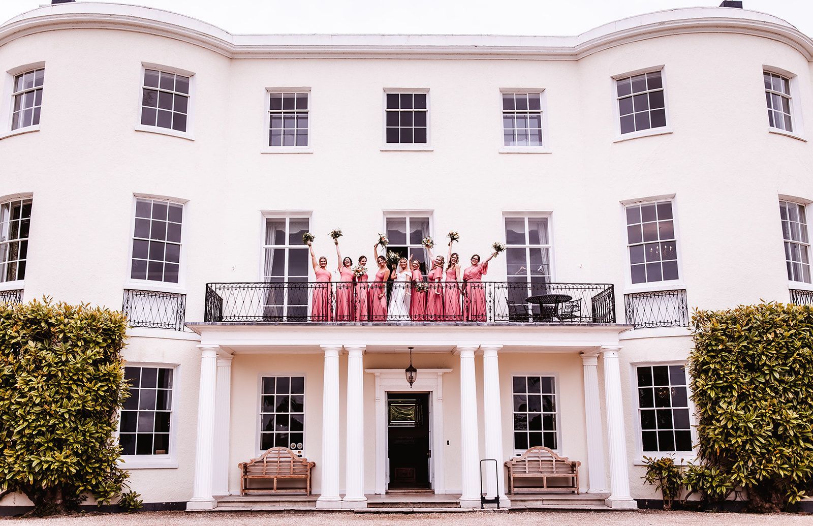 a large white house with a balcony and a blue sky in the background. wedding venue in devon