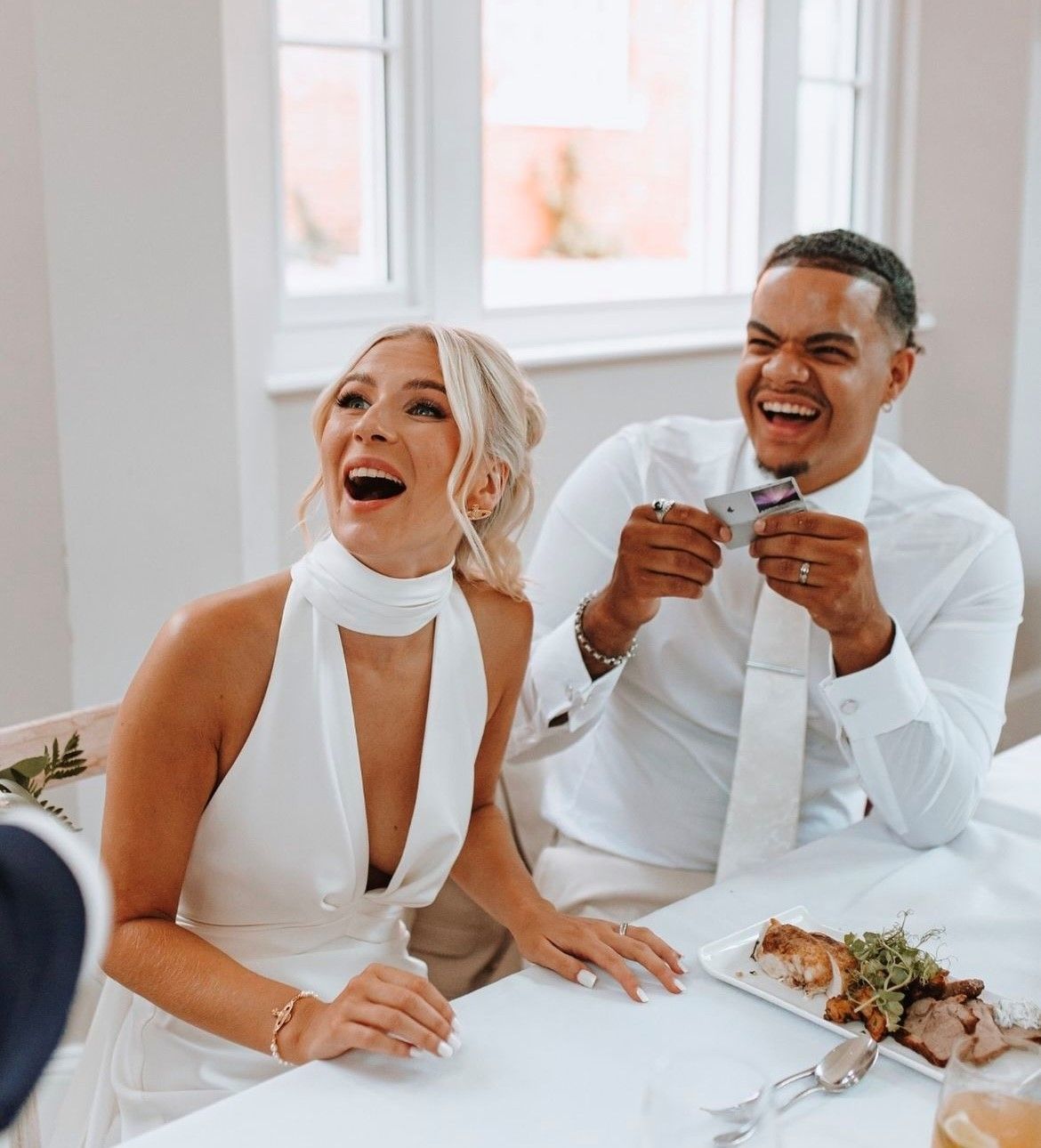 a bride and groom are sitting at a table signing a wedding register .