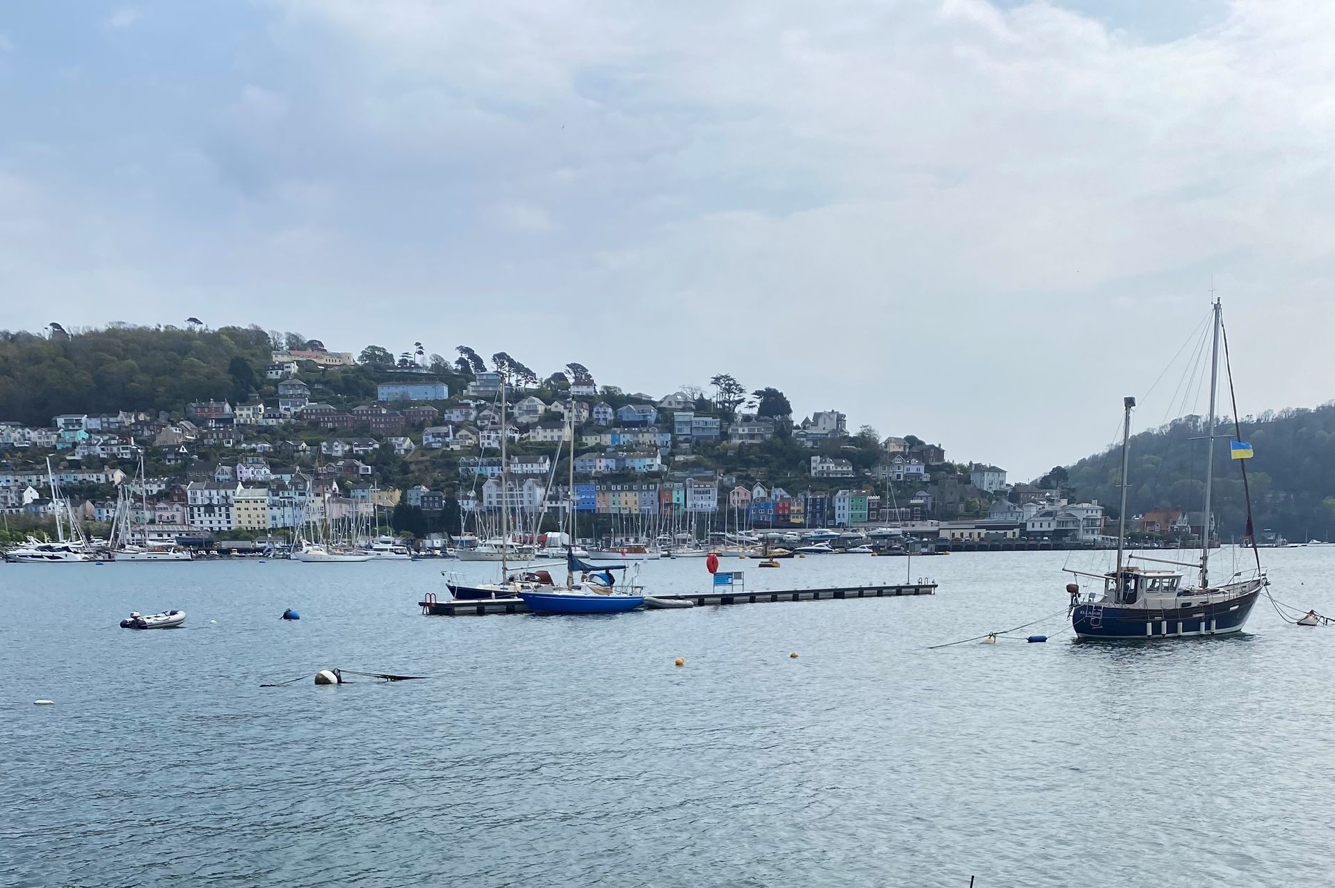 a group of boats are docked in a harbour with a city in the background.